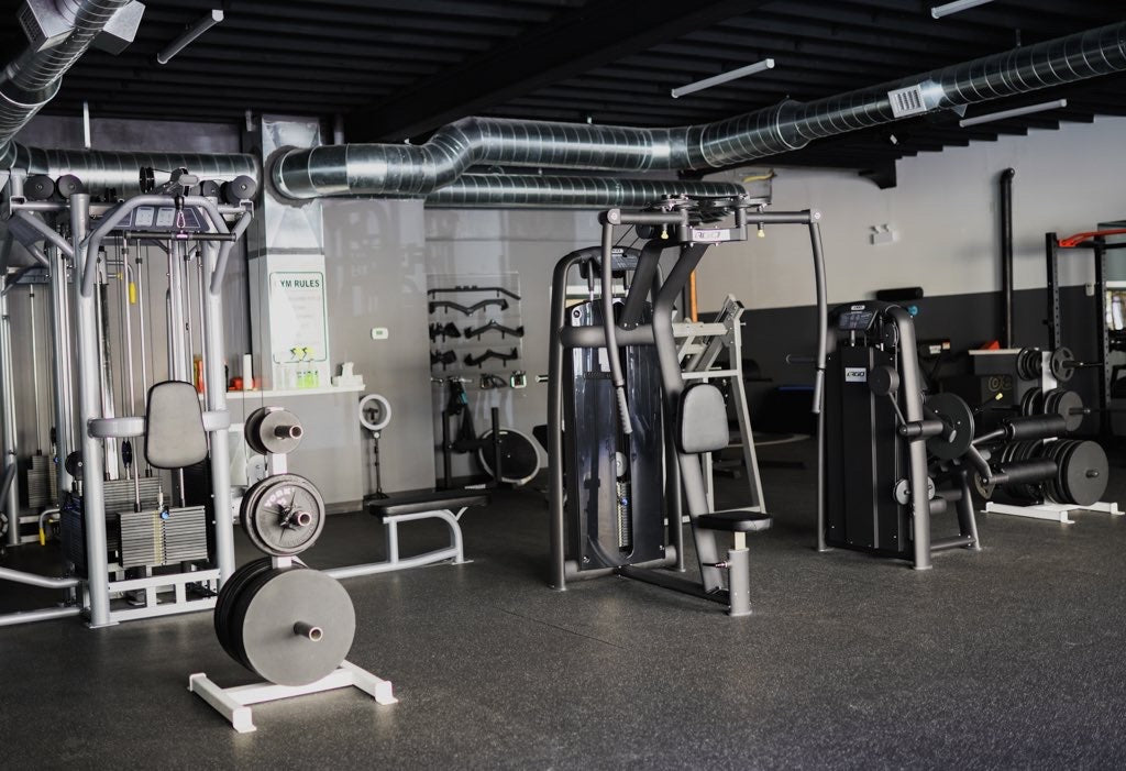 An open shot of part of the training floor, containing plenty of weight-lifting machines and varied assisted bars