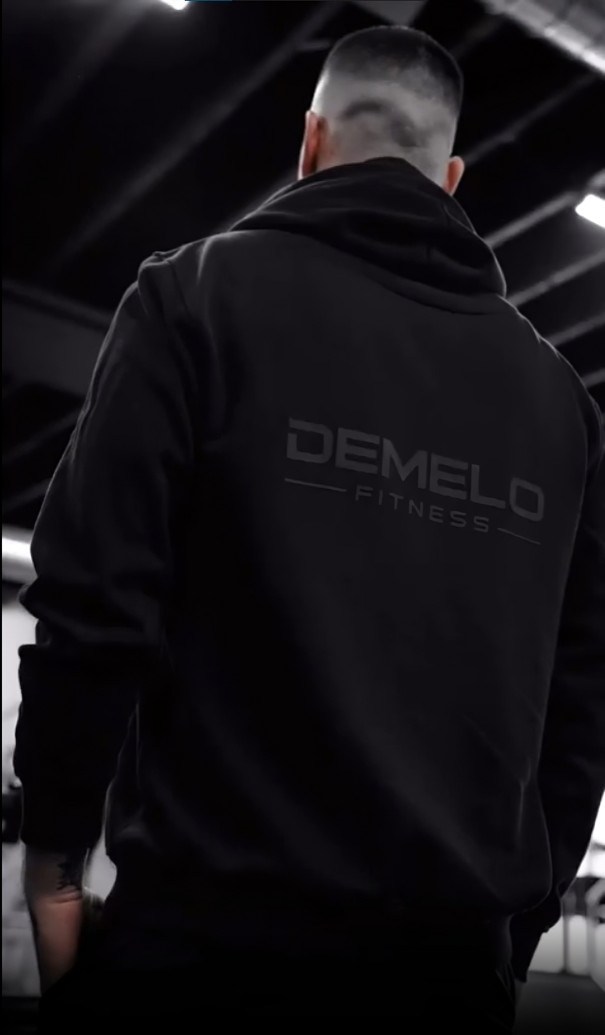 Josh DeMelo facing backwards wearing his brand sweater (black version)